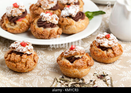 Mini-Kuchen mit Mousse au Chocolat auf Tischdecke serviert. Stockfoto