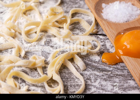 Raw hausgemachte Pasta mit Mehl, Salz und rohes Eigelb über alten Holztisch Stockfoto