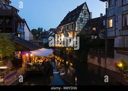 Restaurants im Restaurant Les Bateliers neben dem Fluss La Lauch und Maisons à Colombage im Viertel Petite Venise in Colmar, Elsass, Frankreich Stockfoto