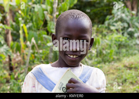 Ein lächelndes ugandischen Mädchen, dass ein Notebook. Stockfoto