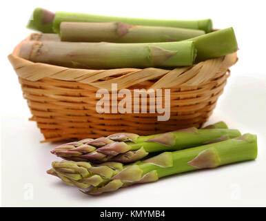 Frischer Spargel in einem Korb auf weißem Hintergrund Stockfoto