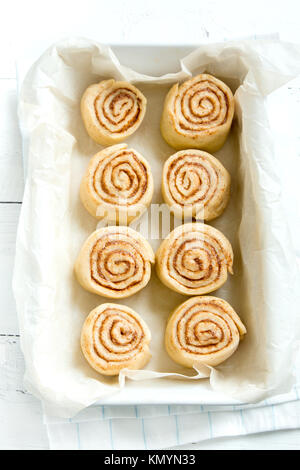 Zimtschnecken oder cinnabon, selbstgemachtes Rezept Rohteig Vorbereitung süß traditionell Dessert Gebäck Gebäck essen auf backblech. Stockfoto