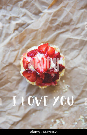 Schöne Muffin mit frischen Erdbeeren liegt auf dem Handwerk Papier, die Inschrift ich liebe Dich. Stockfoto