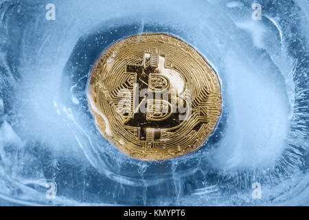 Die Gold Medaille der cryptocurrency Bitcoin ist Einfrieren im blauen Eis. Das Konzept der Austausch im Winter. Stockfoto