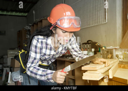 Hübsche asiatische Frau Elektriker oder Techniker prüfen oder prüfen Sie die elektrische Anlage Leistungsschalter auf Power Distribution Panel zu Hause. Stockfoto
