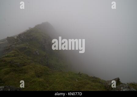 Blick vom Gipfel des Mount Snowdon an einem nebligen Tag, (Nebel/Nebel Wolken auf dem Gipfel des Snowdon) mit den Menschen in den Hintergrund Wandern auf dem Berg. Stockfoto