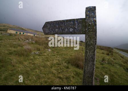 Holz- Wegweiser, die auf Mount Snowden im Snowdonia National Park, auf ein Weitwinkelobjektiv in Wetter. Stockfoto