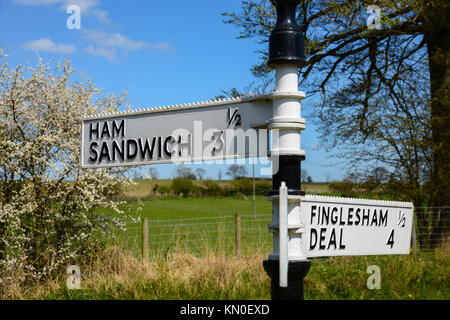 Amüsant lustig altmodische Wegweiser für Schinken Sandwich, Finglesham und Deal in Kent, England mit blauem Himmel, Sonnenschein und grüne Feld hinter Stockfoto