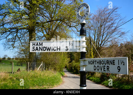 Amüsant lustig altmodische Wegweiser für Schinken Sandwich, Northbourne und Dover in Kent, England mit blauem Himmel, Sonnenschein und grüne Feld hinter Stockfoto