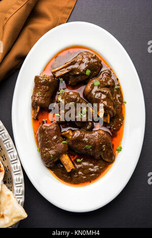 Lammkeule oder Hammel- oder gosht paya oder khoor Curry mit indischen Brot oder Roti oder Naan serviert. Stockfoto