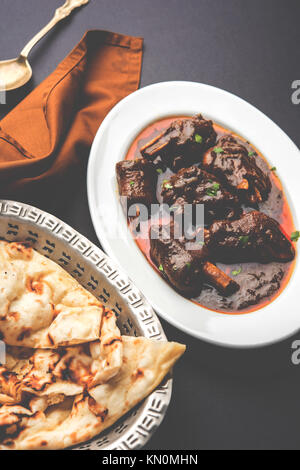 Lammkeule oder Hammel- oder gosht paya oder khoor Curry mit indischen Brot oder Roti oder Naan serviert. Stockfoto