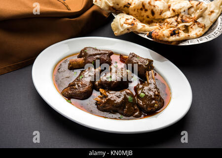 Lammkeule oder Hammel- oder gosht paya oder khoor Curry mit indischen Brot oder Roti oder Naan serviert. Stockfoto