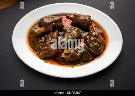 Lammkeule oder Hammel- oder gosht paya oder khoor Curry mit indischen Brot oder Roti oder Naan serviert. Stockfoto