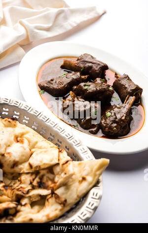 Lammkeule oder Hammel- oder gosht paya oder khoor Curry mit indischen Brot oder Roti oder Naan serviert. Stockfoto