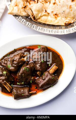 Lammkeule oder Hammel- oder gosht paya oder khoor Curry mit indischen Brot oder Roti oder Naan serviert. Stockfoto