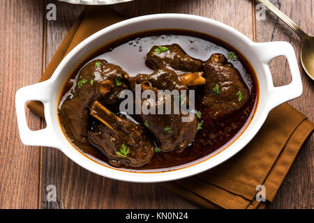 Lammkeule oder Hammel- oder gosht paya oder khoor Curry mit indischen Brot oder Roti oder Naan serviert. Stockfoto