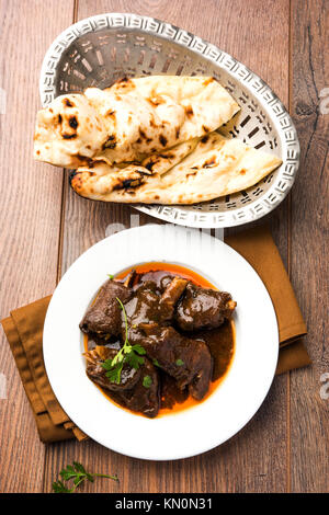 Lammkeule oder Hammel- oder gosht paya oder khoor Curry mit indischen Brot oder Roti oder Naan serviert. Stockfoto