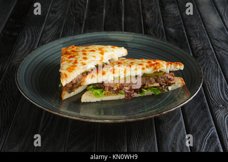 Club Sandwich mit Fleisch, Gurken, Salat und geschmolzenem Käse Stockfoto