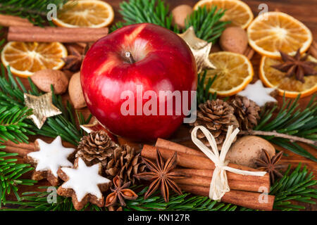 Weihnachten Gewürze mit roten Apfel über alte Holz- Hintergrund Stockfoto