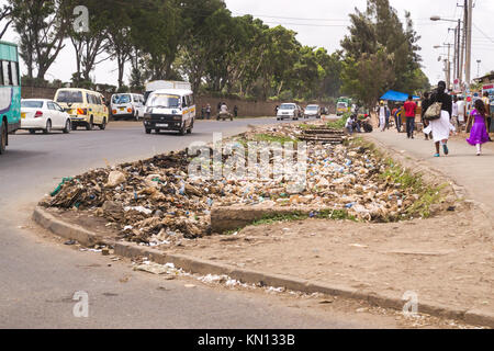 Einen großen Haufen von Kunststoff- und allgemeinen Abfall Abfall liegt an einer befahrenen Straße, d. h. Fahrzeuge, die Vergangenheit und die Fußgänger zu Fuß durch, Nairobi, Kenia, Ost Stockfoto