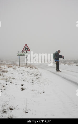 Peak District, Derbyshire, UK. 10 Dez, 2017. Ein Rambler trotzt der Schnee auf die Derbyshire Grenze im Peak District in der Nähe von Sheffield. Credit: Gary Bagshawe/Alamy leben Nachrichten Stockfoto