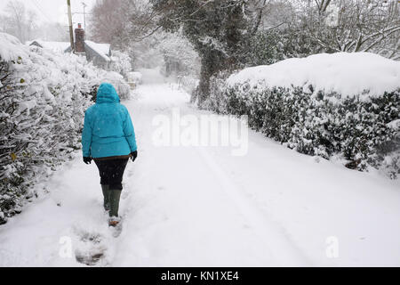 Titley, Herefordshire, UK - Dezember 2017 - ein Fußgänger geht mit Sorgfalt entlang einer ländlichen Straße nach starker Schneefall ein winterwunderland Blick in die ländliche Seite Straßen von Herefordshire - Foto Steven Mai/Alamy Leben Nachrichten bringt Stockfoto