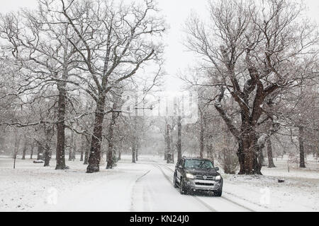 Windsor, Großbritannien. 10. Dezember, 2017. Ein Fahrzeug bewegt sich durch den Schnee im Windsor Great Park. Credit: Mark Kerrison/Alamy leben Nachrichten Stockfoto