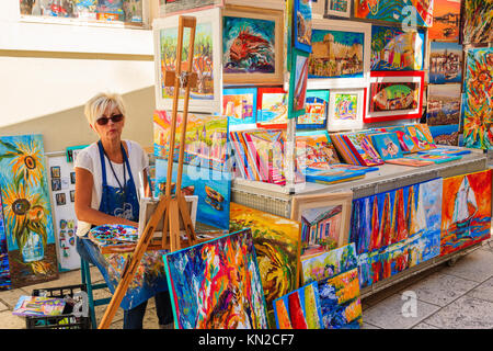 Stadt Trogir, Kroatien - Sep 6, 2017: Frau Künstler malen und verkaufen Bilder in der Altstadt von Trogir, Dalmatien, Kroatien. Stockfoto