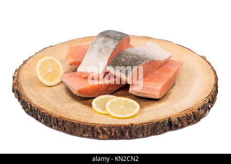 Gefrorenen lachs Fischfilets mit Zitronenscheiben auf Holz board isoliert. Stockfoto