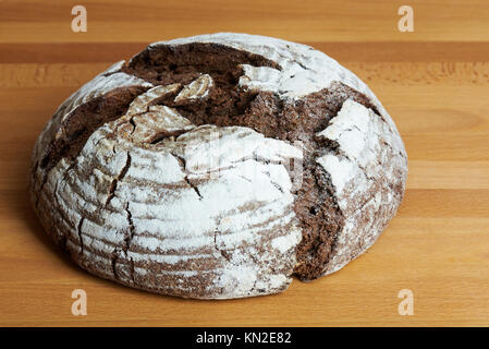 Dunkle runde Brot auf holztisch Nahaufnahme Stockfoto