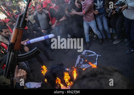 Gaza, Palästina. 09 Dez, 2017. Palästinensische Anhänger der Volksfront für die Befreiung Palästinas (PFLP) Teil in einem Protest gegen US-Präsident ist Trumpf Entscheidung Jerusalem als Hauptstadt von Israel zu erkennen, Palästinensische maskierte bewaffnete Banditen der Volksfront für die Befreiung Palästinas ihre Waffen an ein Bildnis von US-Präsident Donald Trump, in Gaza Stadt, Samstag, Dezember 9, 2017. Credit: Ramez Habboub/Pacific Press/Alamy leben Nachrichten Stockfoto