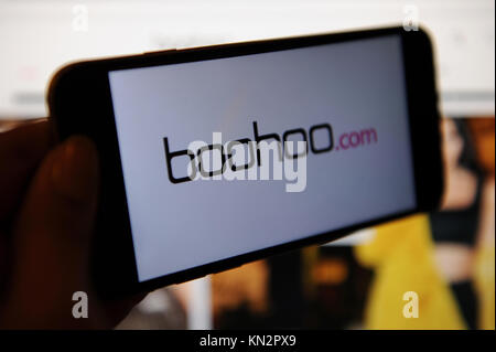 Die Boohoo.com Logo ist auf ein Telefon und die webstite boohoo.com auf einem Bildschirm gesehen Stockfoto