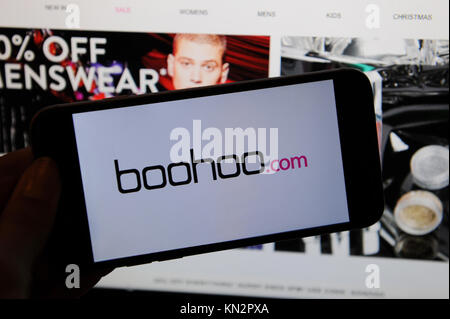Die Boohoo.com Logo ist auf ein Telefon und die webstite boohoo.com auf einem Bildschirm gesehen Stockfoto