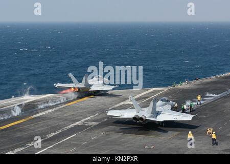 Ein U.S. Navy ea-18g Growler elektronische Kriegsführung Flugzeuge (links) und eines US Navy f/a-18f Super Hornet Jet Fighter Aircraft starten Sie aus dem Flight Deck der US Navy Flugzeugträger der Nimitz-Klasse uss Theodore Roosevelt am 3. Dezember 2017 in den Arabischen Golf. (Foto von Michael Hogan über planetpix) Stockfoto