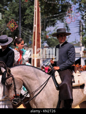 Jerez Horse Fair, Feria del Caballo, junger Mann, der Sherry auf dem Pferd trinkt, das traditionelle Kleid trägt, Jerez de la Frontera, Andalusien, Spanien Stockfoto