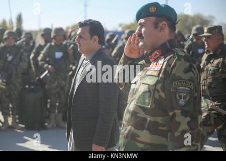 Der erste stellvertretende Gouverneur der Provinz Helmand Sardar Mohammed Hamdard (links) und der afghanischen nationalen Armee kommandierenden General Wali Mohammed Ahmadzai salute Afghanische Soldaten während einer Diplomverleihung an Camp Shorabak Dezember 3, 2017 in Lashkar Gah, Provinz Helmand, Afghanistan. (Foto von Lucas Hopkins über Planetpix) Stockfoto