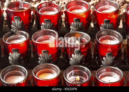 Horizontale dekorative Reihen roter Wachskerzen, spirituelles Friedenssymbol, brennend in der Kapelle des Heiligen Kreuzes römisch-katholische Kirche in der Nähe von Sedona Arizona Stockfoto