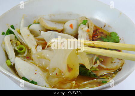 Große Nudel mit Fisch Kugel in Suppe auf Stäbchen Kommissionierung Stockfoto