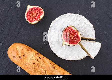 Helle saftige reife Stücke Abb. Obst und cremige Schweizer Camembert Käse und einer knusprigen Golden frische Zwiebel Baguette zum Frühstück. Stockfoto