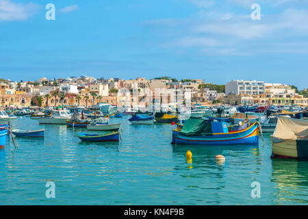 Antenne mit Panoramablick auf die Skyline zu europäischen Hafen mit Dorf Marsaxlokk und traditionelle bunte Luzzu Fischerboote, Malta Stockfoto