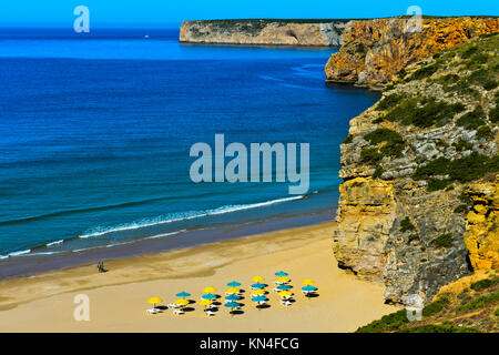 Bucht mit Sandstrand und bunte Sonnenschirme, Beliche Strand Praia do Beliche, Algarve, Portugal Stockfoto