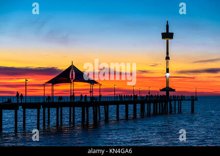 Menschen zu Fuß entlang der Brighton Pier bei Sonnenuntergang. South Australia Stockfoto