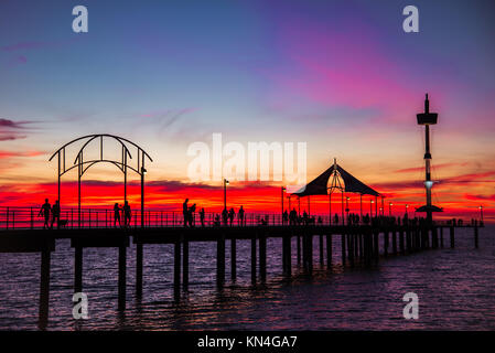 Menschen zu Fuß entlang der Brighton Pier bei Sonnenuntergang. South Australia Stockfoto