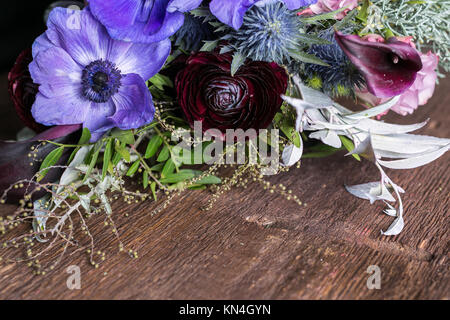 Blumenschmuck, Dekoration, Hochzeit Konzept. Drei absolut in verschiedenen Größen, Farben und Formen Blumen wie battercups anemons, persischen und Lilien sind aus einer harmonischen Bündel Stockfoto