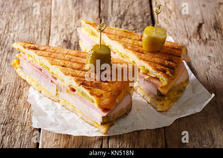 Kubanische Sandwich mit Schinken, Senf, Käse, eingelegte Gurken und Schweinefleisch close-up auf Papier auf dem Tisch. Horizontale Stockfoto