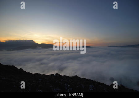 Landschaft der Sonnenaufgang über den Bergen mit Meer Nebel Stockfoto