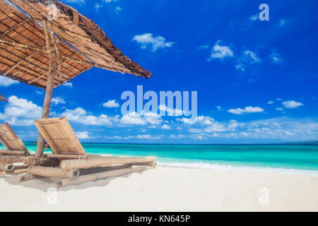 Urlaub ferien Hintergrund - zwei Liegestühle unter Zelt am Strand Stockfoto