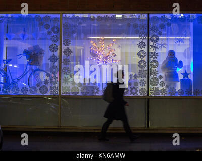 Eine Silhouette von jemanden, der in das Fenster eines Weihnachten Anzeige Stockfoto