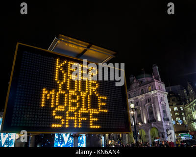 Polizei Schild am Piccadilly Circus Warnung vor Dieben in der Region sowie ihre Xmas Tipple aber kennen ihre Grenzen zu genießen und achten Sie auf Ihr Telefon Stockfoto