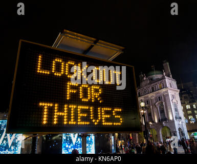 Polizei Schild am Piccadilly Circus Warnung vor Dieben in der Region sowie ihre Xmas Tipple aber kennen ihre Grenzen zu genießen und achten Sie auf Ihr Telefon Stockfoto